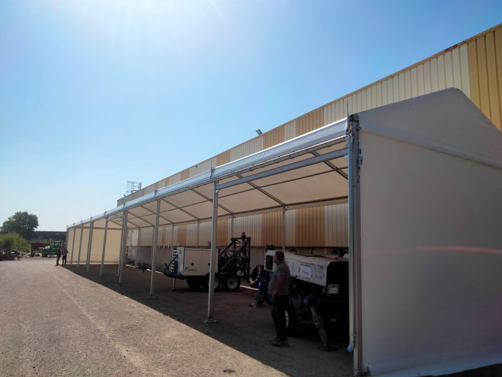Vue extérieure abri engin chantier 40m longueur structure aluminium Saint-Quentin-Fallavier